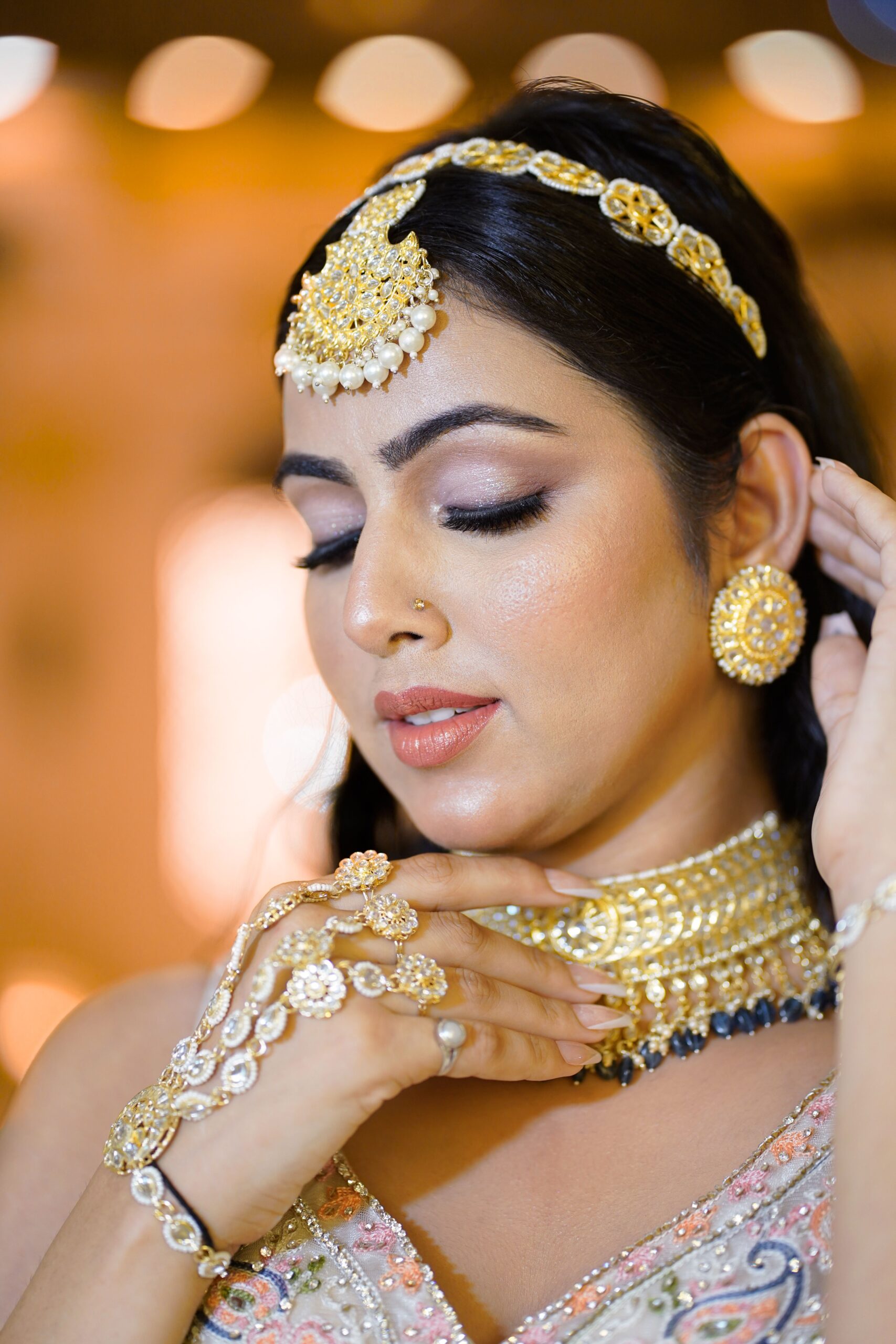 A stunning bridal portrait featuring a woman adorned in elegant gold jewelry, captured in Jaipur, India.